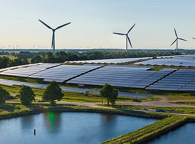 Grüne Landschaft mir Solaranlagen und Windrädern