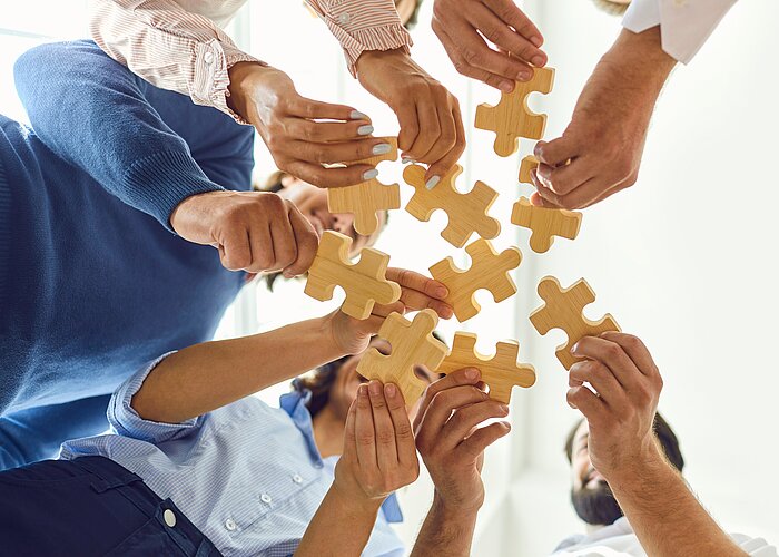 Geschäftsleute setzen als Team ein Puzzle zusammen