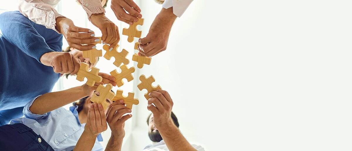 Geschäftsleute setzen als Team ein Puzzle zusammen