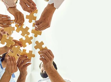 Geschäftsleute setzen als Team ein Puzzle zusammen