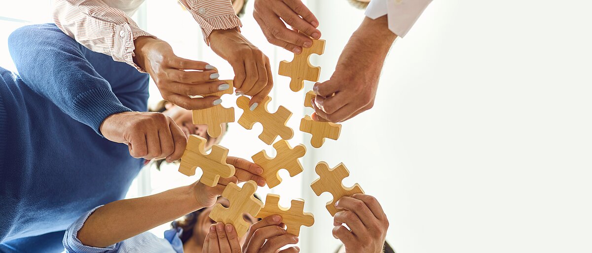 Geschäftsleute setzen als Team ein Puzzle zusammen