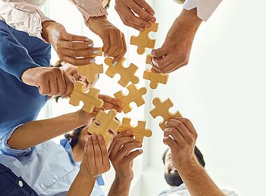 Geschäftsleute setzen als Team ein Puzzle zusammen