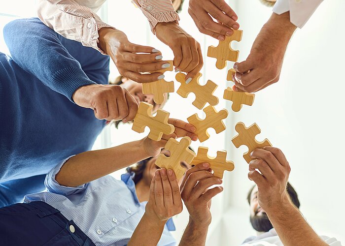 Geschäftsleute setzen als Team ein Puzzle zusammen