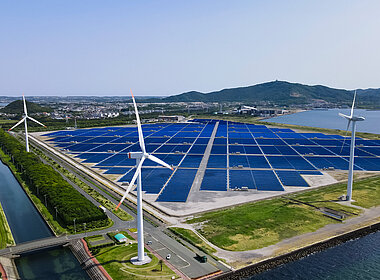Solaranlagen und Windräder in einer grünen Landschaft