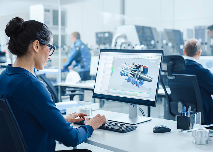 Frau arbeitet am Schreibtisch mit einem CAD-Programm