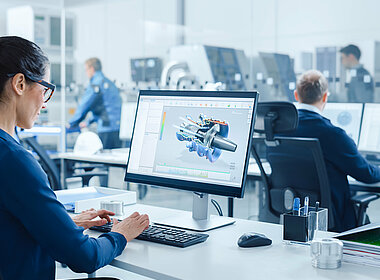 Frau arbeitet am Schreibtisch mit einem CAD-Programm