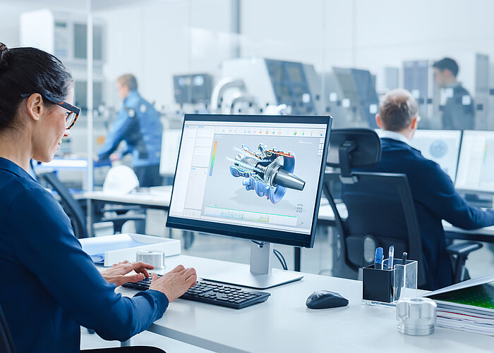 Frau arbeitet am Schreibtisch mit einem CAD-Programm